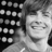 Black-and-white pixelated image of a person with curly hair smiling, featuring text 'ZAC ROCKS' in the upper right corner against a patterned background.