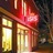 Pixelated image of a red and gold theater facade with vertical columns and a glowing yellow sign on the left.