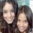 Two people with dark hair pose closely together in a pixelated static image, one person's face partially overlaps the other.
