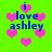 Pixelated green background with pink hearts and blue text reading "i love ashley" in four repeated sections.
