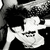 Black-and-white pixelated icon shows a figure with spiky hair holding a guitar, rendered in high-contrast monochrome with visible pixelation.