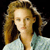 Pixelated image of a person with light brown hair styled in a high ponytail, wearing a light blue patterned top against a black background.