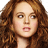 A static image featuring a person with curly red hair on the left, next to purple and pink text reading "WATCH YOUR BACK" and "MEAN GIRLS" with release details.