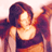 Pixelated static image of a person with long dark hair wearing a sleeveless top, set against warm-toned background gradients.
