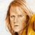 Pixelated close-up of a person with light brown hair and a yellow garment against a light background.