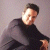 Pixelated image of a person in a dark shirt with arms crossed against a light background.