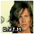 Pixelated image of a person with light brown hair against a two-tone background, featuring black and white pixelated text at the bottom.