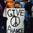 Static pixel art shows a person wearing a white T-shirt with 'GIVE PEACE A CHANCE' text and peace symbol, orange hair visible above shirt collar.