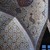 Pixelated static image of a figure in light-colored clothing against a dark background with indistinct shapes.