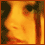 A pixelated profile image of a person's face in warm orange tones, showing subtle shifts in facial expression