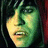 Pixelated close-up of a stylized face with green and yellow tones, featuring closed eyes, visible teeth, and a curved mouth against dark background.