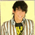 Pixelated image of a person with short dark hair wearing striped shirt and yellow tie against light background.
