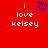 Red background with white text reading 'i love kelsey' and a blue pixelated heart symbol above the text.