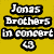 Pixelated text on yellow background reads 'Jonas Brothers In concert 49' with black outlines and white fill.