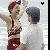 Pixelated static icon showing two figures in swimwear, one with red hair and maroon bikini, the other with dark hair and white top, against a light background with small black heart symbol.