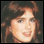 Static pixelated image of a person's face with brown hair and light skin tone against dark background, rendered in low-resolution style typical of early 2000s digital art.