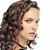 Pixelated close-up of a person's face with curly brown hair, light skin, and a neutral expression against a white background.