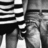 Black-and-white pixelated image showing a partial figure with striped patterns and abstract shapes, likely a stylized representation of a character or object.