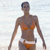 Static pixelated image of a person in an orange bikini standing against a light background with visible dithering and low-resolution rendering artifacts.