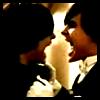 Static close-up of two figures kissing with blurred background and high-contrast lighting.