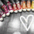 A heart-shaped outline icon with a blurred background of colorful objects and a gray gradient backdrop.