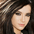 Pixelated close-up of a person with long dark hair, light skin tone, and subtle makeup including eyeliner and pink lips.