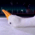 A pixelated image shows a white object with an orange tip against a dark background, featuring blurred vertical lines and scattered light spots.