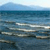 A static pixelated image of a calm ocean scene with blue water and white wave crests under a light sky.
