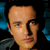 A 50x50 pixel animated buddy icon featuring a close-up of a person's face on the left, with text and logos on the right against a black background.