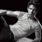 Pixelated grayscale image of a person in a dynamic pose with one arm extended forward and the other arm bent behind, set against a solid black background.