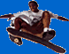 A person in a white shirt and brown shorts performs a mid-air skateboard trick against a blue background with yellow 'E-MAIL' text.