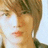 Pixelated close-up of a person's face with light brown hair, closed eyes, and a neutral expression against a light background.