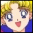 Pixelated anime-style character with blonde hair and blue eyes, smiling with open mouth, wearing blue top against black background with text.