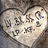 Heart-shaped icon with engraved text and symbols on a textured background, showing subtle animation changes.