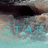 Pixelated static image showing a dark curved shape above a light blue and gray gradient background with scattered turquoise patches.