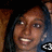 Pixelated close-up of a person with brown hair and dark eyes, wearing a blue garment against a black background.