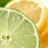 A static image with a green background displaying a close-up of a lemon slice and a lime slice, accompanied by blue pixelated text.