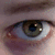 A close-up of a human eye with brown iris and visible eyelashes, showing sequential text overlays in a