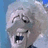 Pixelated close-up of a character with light-colored hair, dark eyes, and an open mouth against a blue background.