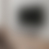 A static pixelated image with a gradient of gray and brown tones forming a blurred square shape in the center against a lighter background.