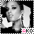 Black-and-white pixelated image of a person with hand near head, wearing large earrings, with 'AKO' text in pink and white at bottom right.
