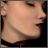 Pixelated close-up of a person's face in profile view showing skin tone, nose, mouth, and dark hair against black background.