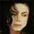 Static 50x50 pixel icon showing a close-up of a person's face with light skin, brown hair styled in waves, and neutral expression against dark background.