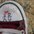 A static icon shows a stylized figure holding a red heart above its head, standing on a white background with dark curved lines framing the scene.