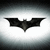 A dark bat-shaped symbol with outstretched wings appears against a bright white background with a soft gray gradient, positioned centrally in the frame.