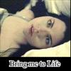 A person with dark hair lies on a light surface, wearing a sleeveless top; the text "Bring me to Life" appears below.