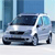Pixelated image of a silver sedan with dark tinted windows, positioned at a three-quarter angle against a blue-toned urban background.