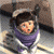 Animated character in purple hooded outfit with white trim, performing sequential facial expressions and head movements against a blurred background.