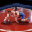 Animated sequence of two wrestlers on a red mat, one in orange singlet and blue shorts grappling with another wrestler in blue singlet and white shoes.