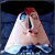 Animated icon features a character with a triangular face, red hair, and blue eyes against a dark blue background with white text.